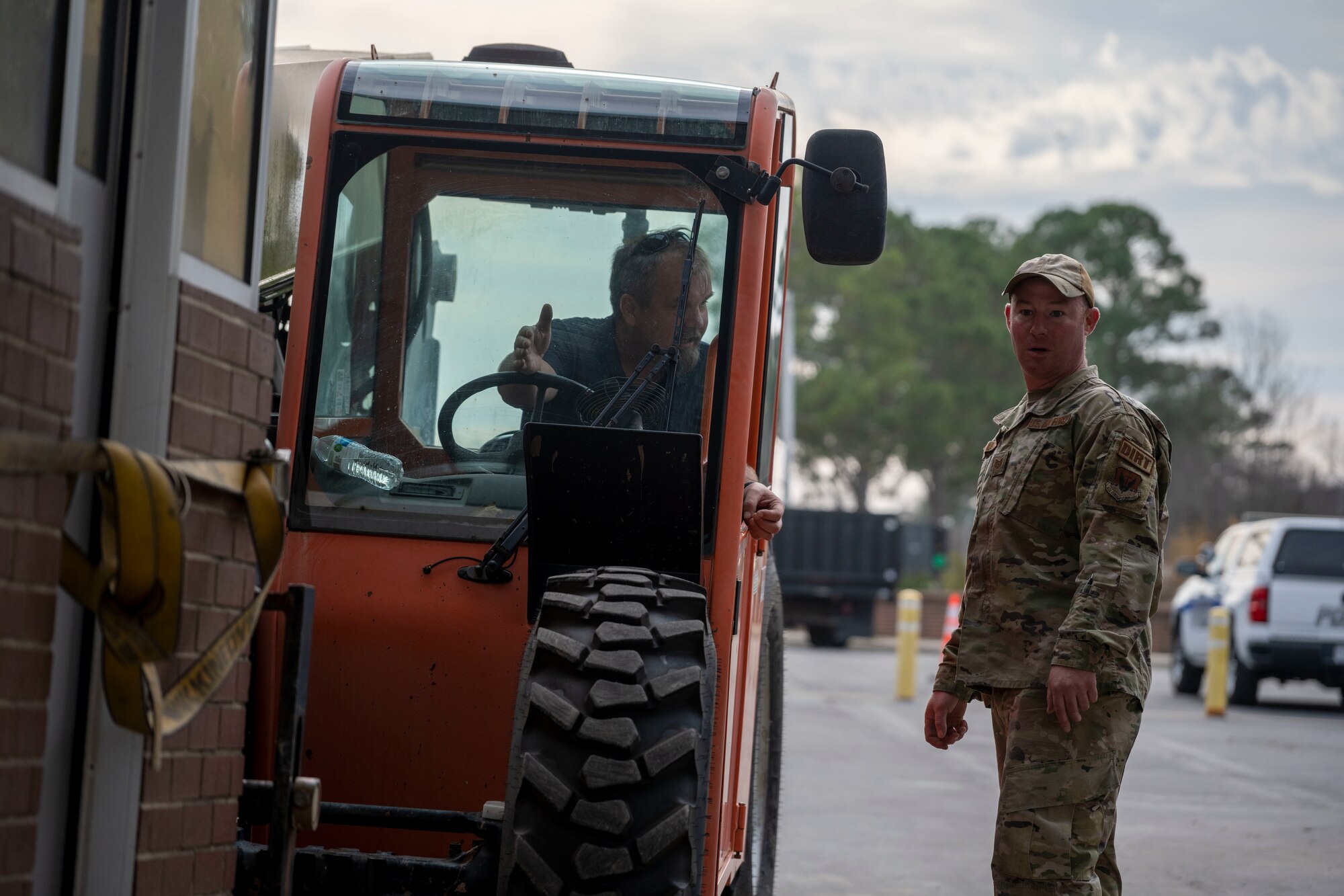 Tech. Sgt. Brian Ashworth and Paul Walker, both 4th CES pavements and equipment technicians, position a pre-engineered building during a sight survey at Seymour Johnson Air Force Base, North Carolina, Jan. 3, 2023. The PEB was positioned as a model building in order to properly measure clearance for passing vehicles after the gate’s update. (U.S. Air Force photo by Senior Airman Kevin Holloway)
