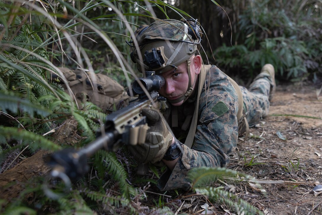 U.S. Marine Corps Lance Cpl. David Bibby, a machine gunner with 1st Battalion, 2nd Marines, 3d Marine Division, provides security during a squad competition at the Jungle Warfare Training Center on Camp Gonsalves, Okinawa, Japan, Jan. 26, 2023.