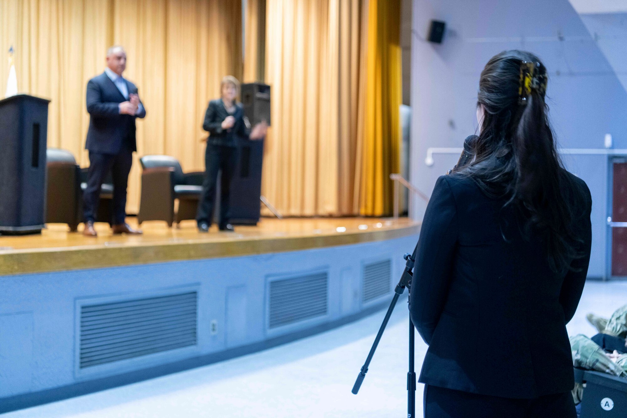 A member of Yokota community asks Gilbert Cisneros Jr., Under Secretary of Defense for Personnel and Readiness, left, and Seileen Mullen, Acting Assistant Secretary of Defense for Health Affairs, a question during a town hall at Yokota Air Base, Japan, Jan. 30, 2023.