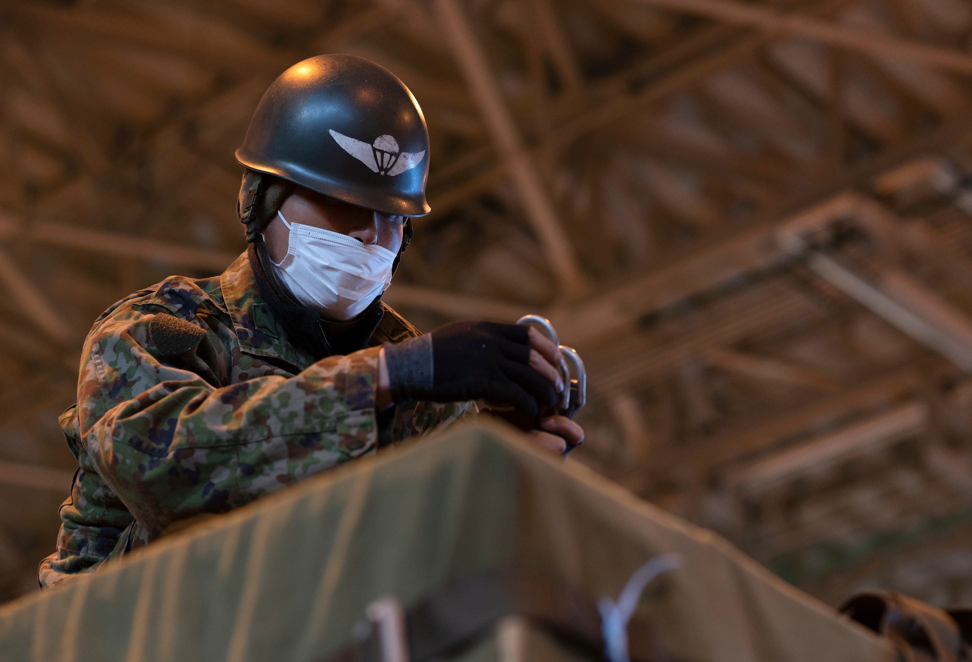 A soldier from the Japan Ground Self-Defense Force secures a Containerized Delivery System bundle
