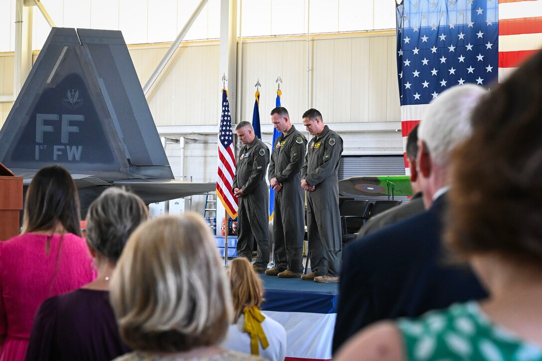 Attendees pray during ceremony.