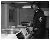 A USCG African-American ETC working with an early computer