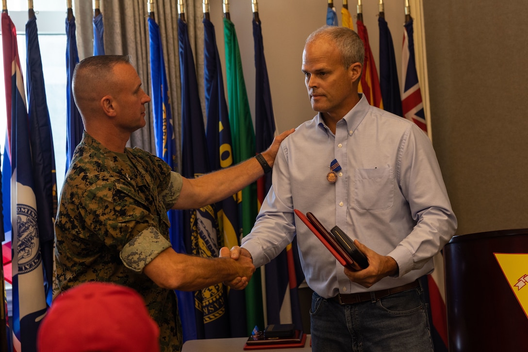 U.S. Marine Corps Col. Brendan Burks, U.S. Marine Corps Air Station Cherry (MCAS) Point commanding officer congratulates James Herring, Heating Ventilation and Air Conditioning Equipment Mechanic, during the Civilian of the Year award ceremony at Miller’s Landing, MCAS Cherry Point, North Carolina, June 5, 2023. The ceremony spotlighted six total awardees from various departments on the installation who exceeded performance expectations to serve the MCAS Cherry Point community and beyond. (U.S. Marine Corps photo by Cpl. Jade Farrington)