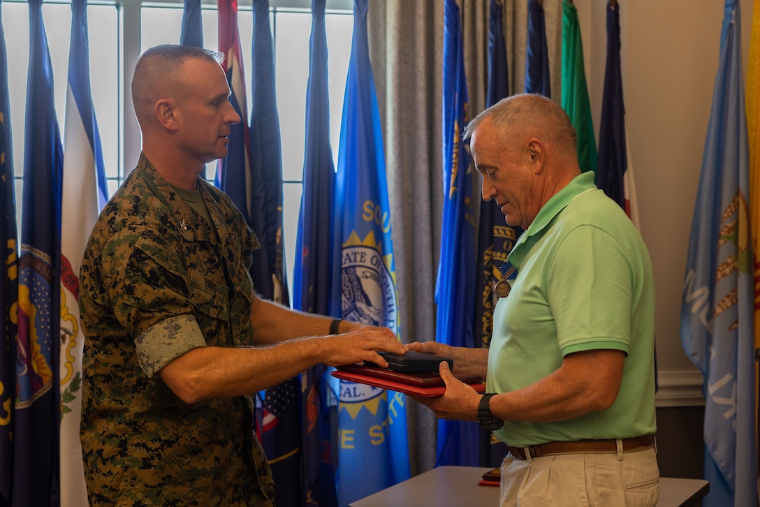 U.S. Marine Corps Col. Brendan Burks, U.S. Marine Corps Air Station Cherry (MCAS) Point commanding officer congratulates Thomas Denninger, Work Center 45 supervisor, during the Civilian of the Year award ceremony at Millers Landing, MCAS Cherry Point, North Carolina, June 5, 2023.  The ceremony spotlighted six total awardees from various departments on the installation who exceeded performance expectations to serve the MCAS Cherry Point community and beyond. (U.S. Marine Corps photo by Cpl. Jade Farrington)