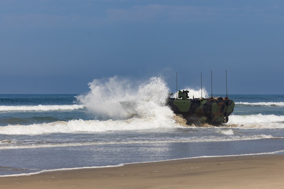 A Marine Corps vehicle drives from the shore into open water.