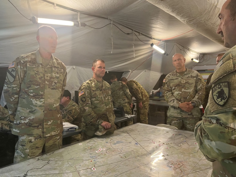 Brig. Gen. Brian Wertzler, State Command Sgt. Maj. Jesse Withers, and Command Chief Warrant Officer Ricky Skelton are briefed by Col. Armstrong on the current status of the exercise. The 63rd TAB participated in warfighter 23-05 as a combat aviation brigade supporting the III Corps.