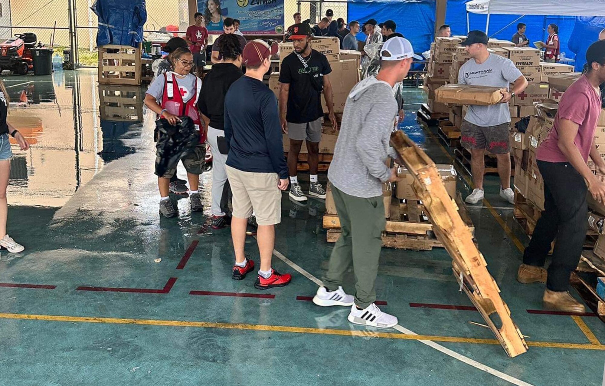 U.S. Air Force Tech. Sgt. Mark Eastman, third from right, 51st Logistics Readiness Squadron fuels distribution NCOIC, moves a pallet in Guam during Typhoon Mawar recovery operations near Andersen Air Force Base, Guam. Eastman and his team assisted the Red Cross in delivering aid to remote villages by visiting 1,300 families and distributing over 103,000 pounds of aid. (Courtesy photo)