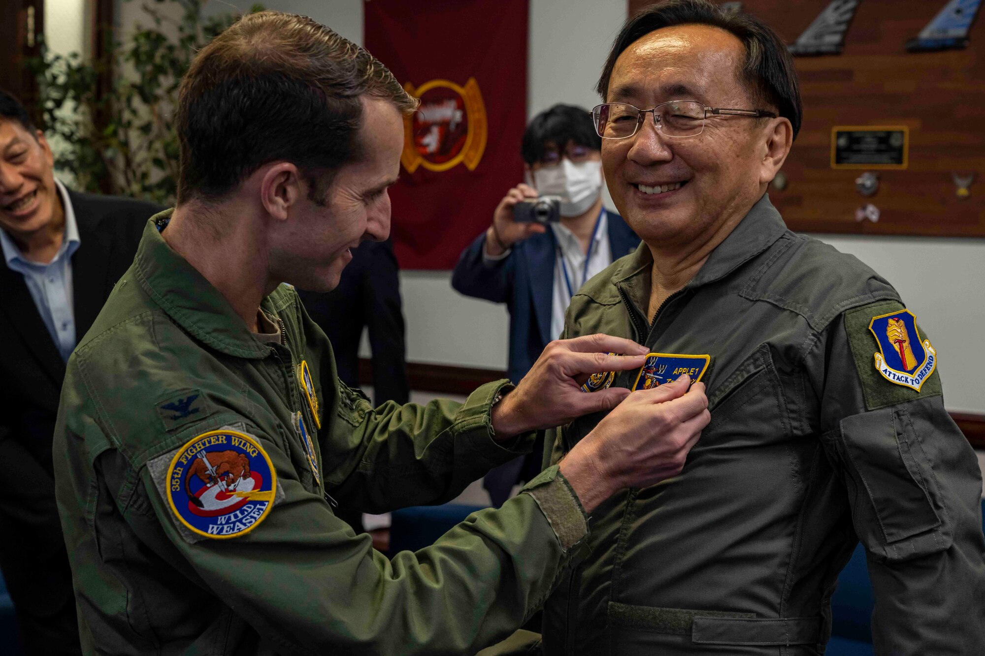 Misawa Air Base commander puts a nametape onto the Aomori Governor during a ceremony