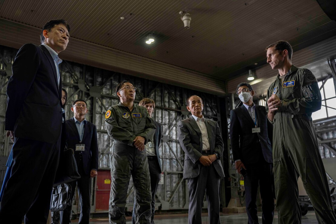 A group of people talking inside a hangar at Misawa Air Base.