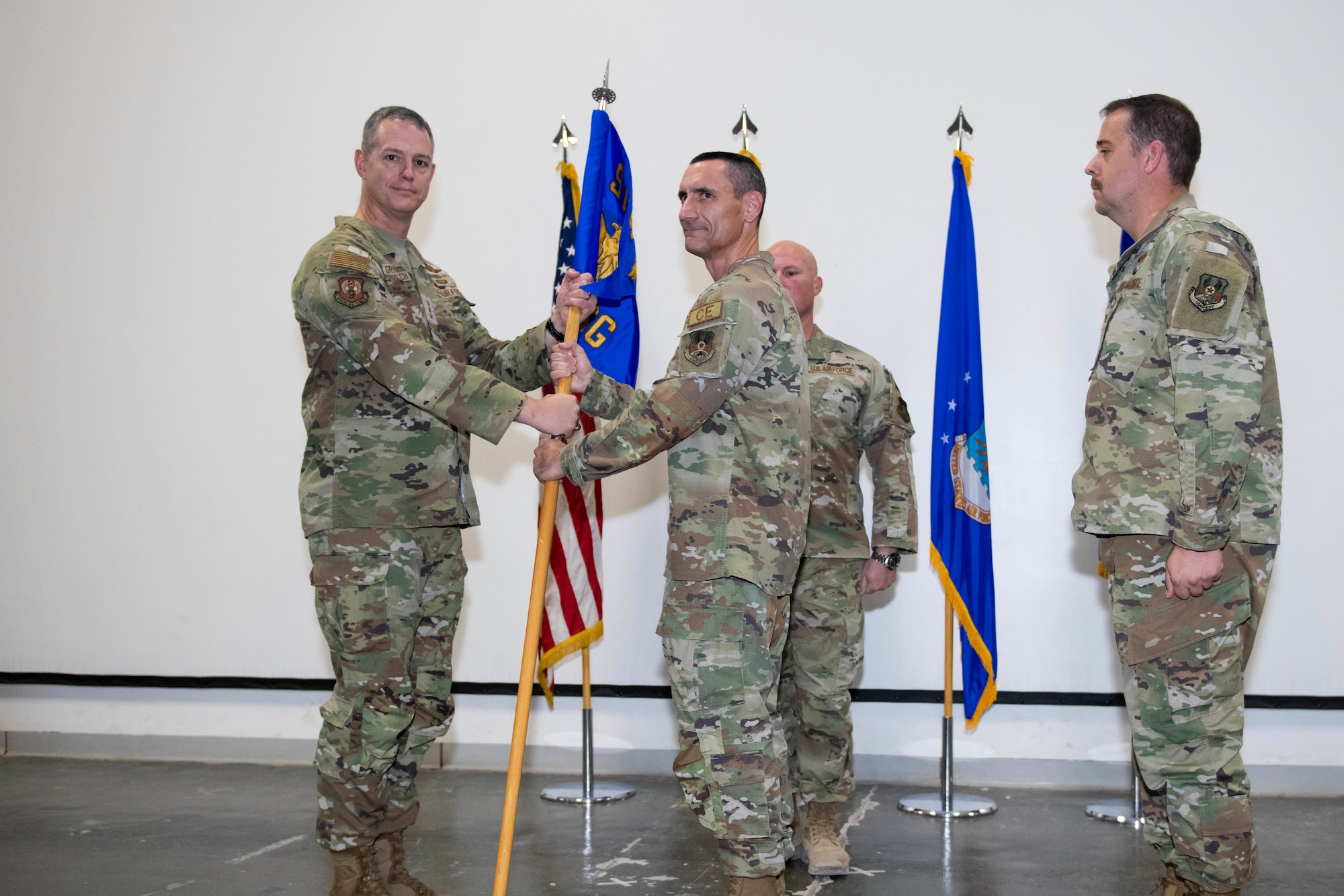 U.S. Air Force Col. Anthony Figiera, center, 9th Air Force (Air Forces Central) 1st Expeditionary Theater Support Group (ETSG) outgoing commander, relinquishes command to U.S. Air Force Lt. Gen. Alexus Grynkewich, Ninth Air Force (Air Forces Central) commander and Combined Forces Air Component Commander for U.S. Central Command, left, during the ETSG activation and change of command ceremony July 3, 2023, at Al Udeid Air Base, Qatar. Since its inception in March, the ETSG has successfully conducted missions across 12 different bases in eight countries. The group consists of multi-capable Airmen with expertise from engineering, logistics and communications to conduct more effective warfighting missions. (U.S. Air Force photo by Staff Sgt. Jennifer Zima)