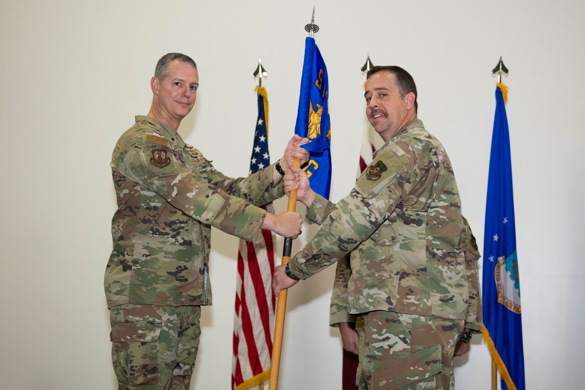 U.S. Air Force Col. Glenn Cameron, right, 9th Air Force (Air Forces Central) 1st Expeditionary Theater Support Group (ETSG) incoming commander, assumes command from U.S. Air Force Lt. Gen. Alexus Grynkewich, Ninth Air Force (Air Forces Central) commander and Combined Forces Air Component Commander for U.S. Central Command, left, during the ETSG activation and change of command ceremony July 3, 2023, at Al Udeid Air Base, Qatar. Since its inception in March, the ETSG has successfully conducted missions across 12 different bases in eight countries. The group consists of multi-capable Airmen with expertise from engineering, logistics and communications to conduct more effective warfighting missions. (U.S. Air Force photo by Staff Sgt. Jennifer Zima)