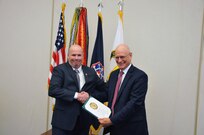 Department of the Army Criminal Investigation Division Deputy Directory, Robert Tracy, presents Guy Surian with a 50 year Federal Career Service Award Certificate for his five decades of service to the U.S. Army.