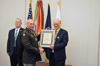 Chief Warrant Officer 5 Paul Arthur, on behalf of the Military Police Regimental Association, presents Guy Surian with the Order of the Marechaussee in Gold.