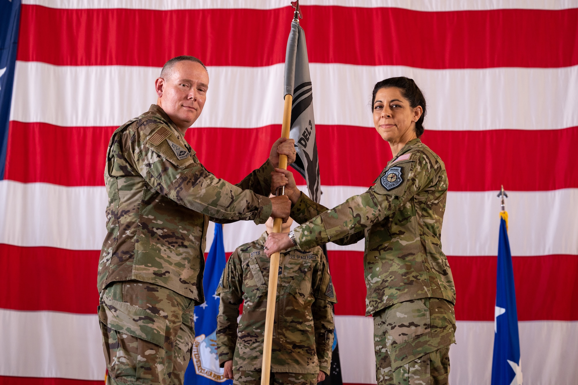U.S. Air Force Maj. Gen. Patrick Cobb, Air National Guard Assistant to the Commander, U.S. Space Operations Command, (left) gives the Space Base Delta 3 guidon to U.S. Space Force Col. Nicole Petrucci, incoming DEL 3 commander, (right) June 29, 2023, at Peterson Space Force Base. DEL 3 operates electronic attack, protection, and support capabilities to protect and defend the space domain. (U.S. Space Force photo by Airman 1st Class Cody Friend)