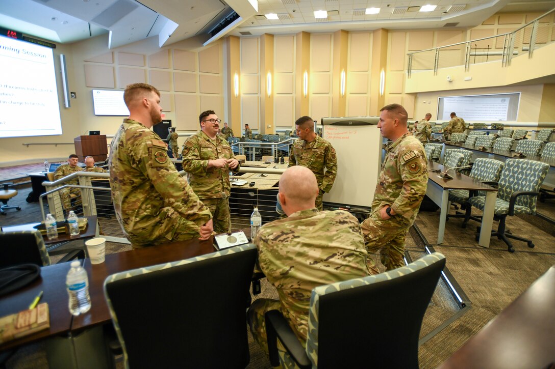 A group of military members writes down notes.