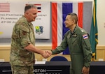 Brig. Gen. Gent Welsh, commander of the Washington Air National Guard, shakes hands with Group Capt. Anurruk Romnarak, Royal Thai Air Force, at Camp Murray, Wash., June 30, 2023, at the final planning conference for an air refueling exercise later this year in Thailand. The Washington Guard and Thailand are partners in the Department of Defense National Guard Bureau State Partnership Program.