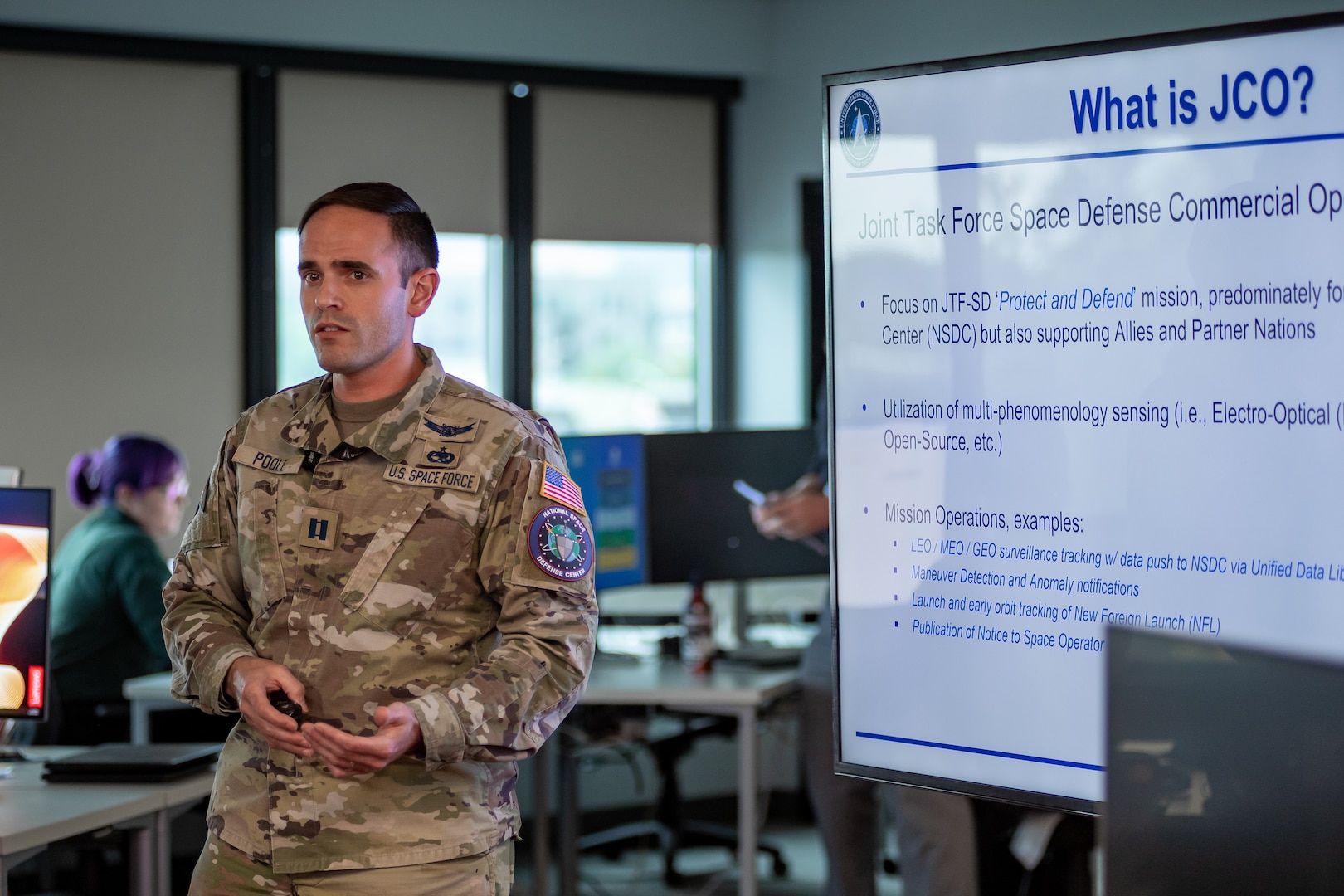 Man in military uniform briefing slideshow