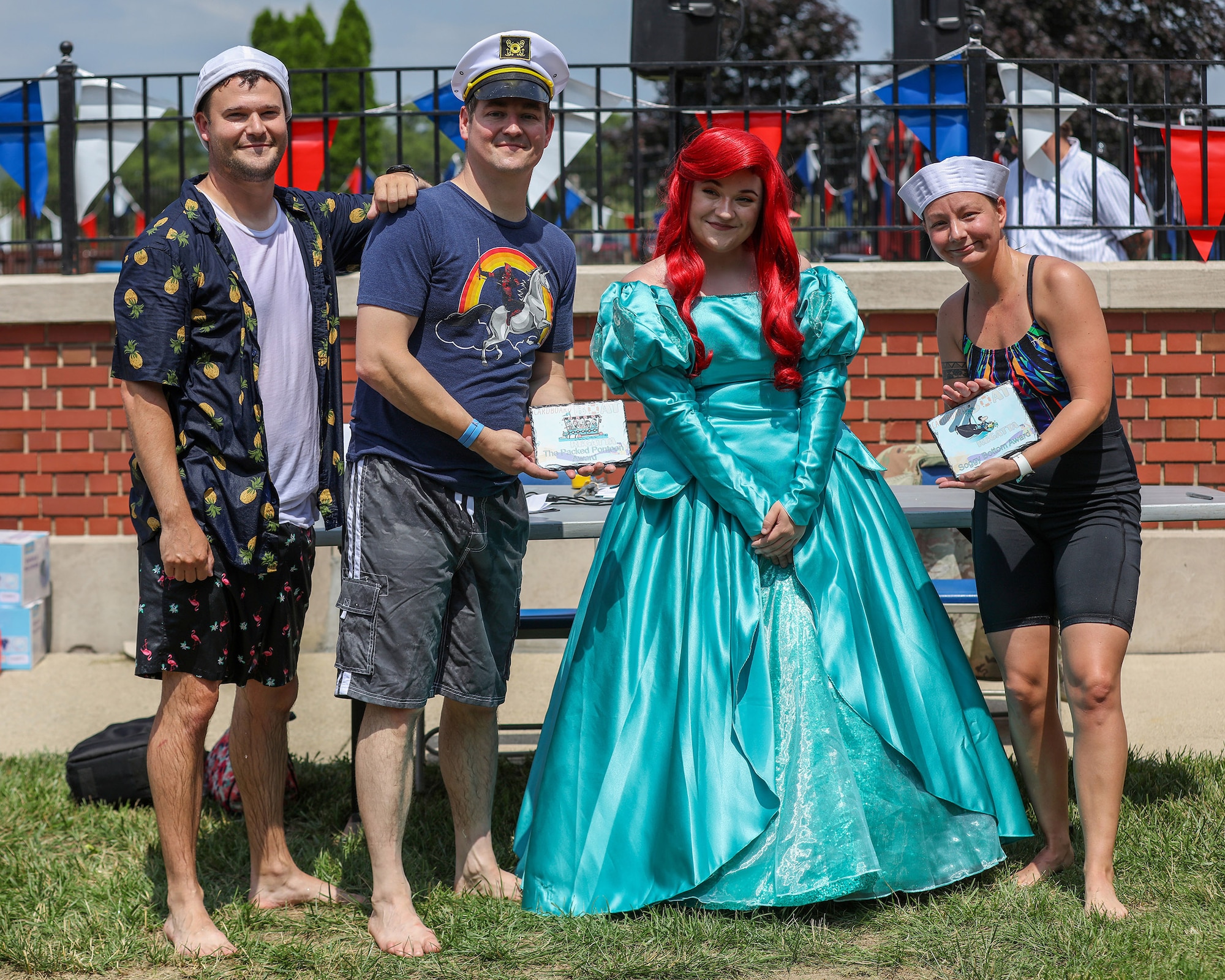 (Left to right) Staff Sgt. Lawrence Depasquale and Master Sgt. Bradley Swindall, both 445th Maintenance Squadron aircraft structural maintenance mechanics, and their teammate, Senior Airman Stephanie Gillespie, 445th MXS fabrication flight non-destructive inspection technician, pose for the camera after finishing the Wright-Patterson Air Force Base Cardboard Boat Regatta held on base at Patterson Pool June 30, 2023. They won “The Packed Pontoon Award” for most people on a boat and “The Soggy Bottom Award” for having the last boat standing during the battle royal in which the participants attempt to sink each other’s boats by ramming or filling with water by use of water guns or buckets. The 445th MXS team made their boat, Ship for Brains, out of cardboard, glue and tape. Ten teams participated in the event this year with more than 100 people in attendance.