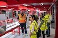 Members of U.S. Army Medical Logistics Command’s Integrated Logistics Support Center tour the U.S. Army Medical Materiel Center-Europe in late May. Pictured, from left in yellow vests, are data scientists Julia Contarino and Tajesvi Bhat, and Arthur Braithwaite, director of the ILSC’s Logistics and Technical Support Directorate. The LTSD data analysis team visited USAMMC-E to learn more about operations, provide training and support the setup of an analytics dashboard to help streamline operations. (U.S. Army photo by Joel Cook)