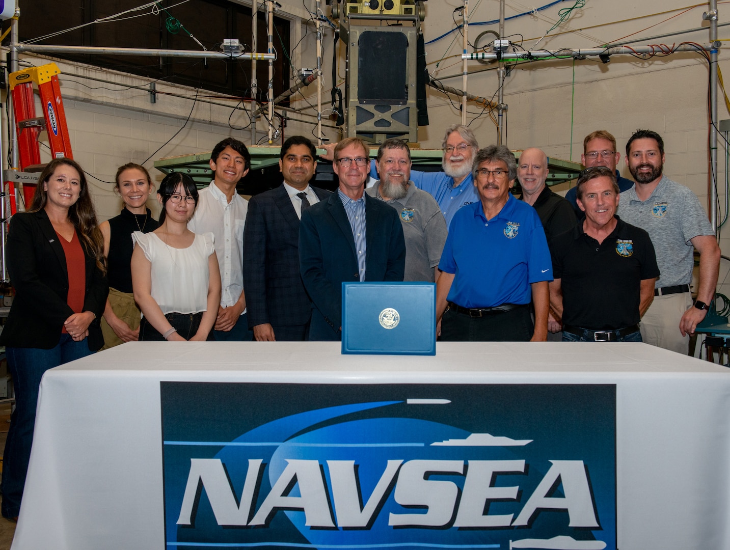 delegation from Naval Surface Warfare Center Panama City Division, Brown University, Office of Naval Research, Duke University and Human Systems Integrations commemorate the signing of a Cooperative Research and Development Agreement (CRADA), May 22. The CRADA aims to develop technology solutions to protect high speed craft operators from injurious environmental conditions, specifically the repeated mechanical shock a body endures when quickly navigating open water. (U.S. Navy photo by Sgt. Alex Morgan)