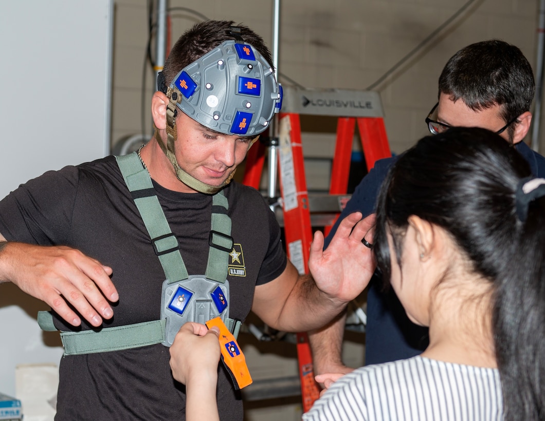 Sayaka Kochiyama, Brown University School of Engineering graduate student, adjusts the Accelo-Suit on a U.S. Coast Guard sailor, May 23. The Accelo-Suit is collectively comprised of the Accelo-Hat and Accelo-Harness and these inertial measurement devices measure kinematics data. (U.S. Navy photo by Ronnie Newsome)