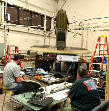 (left) Jeff Kiser, Naval Surface Warfare Center Panama City Division (NSWC PCD) Unmanned Systems Branch engineer monitors accelerometer data collection while Eric Pierce, NSWC PCD Test and Evaluation senior test director, leads high speed craft operator test activities, May 23. The U.S. Coast Guard participant is leaning on the bolster and the platform is in motion during one of the exposure trials. (U.S. Navy photo by Ronnie Newsome)