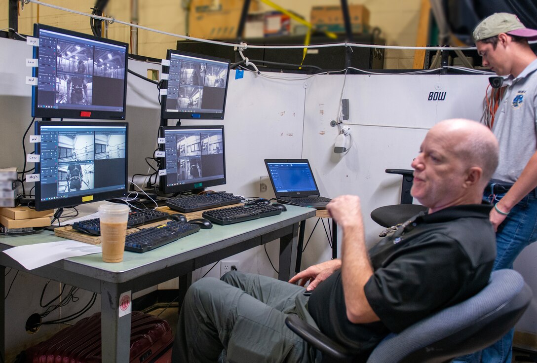 (front) Dr. Dale Bass, Duke University, and Blake Draut, Naval Surface Warfare Center Panama City Division Human Systems Integration (HSI) monitor video and force plate data collection, May 23. HSI is a required systems engineering process in defense acquisition to provide a disciplined, unified, and interactive approach to integrate human considerations across system design to optimize total system performance and minimize life-cycle costs. (U.S. Navy photo by Ronnie Newsome)