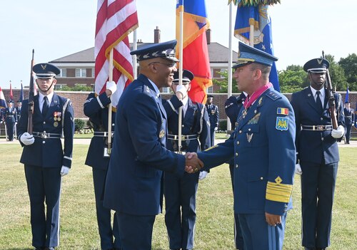 Air Force Chief of Staff Gen. CQ Brown, Jr. presents the Legion of Merit medal to Chief of the Romanian Air Force Staff Lt. Gen. Viorel Pană during a full honors arrival ceremony at Joint Base Anacostia-Bolling, Washington, D.C., June 27, 2023.