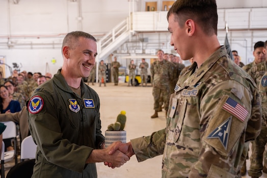  U.S. Air Force Col. Chris Buckley, husband of U.S. Space Force Col. Nicole Petrucci, receives a cactus as a welcome gift during Delta 3-Space Electromagnetic Warfare’s change of command June 29,2023, at Peterson Space Force Base. (U.S. Space Force photo by Airman 1st Class Cody Friend)