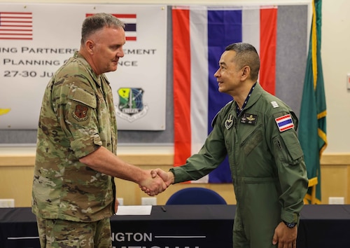 Brig. Gen. Gent Welsh, commander of the Washington Air National Guard, shakes hands with Group Capt. Anurruk Romnarak, Royal Thai Air Force, at Camp Murray, Wash., June 30, 2023, at the final planning conference for an air refueling exercise later this year in Thailand. The Washington Guard and Thailand are partners in the Department of Defense National Guard Bureau State Partnership Program.