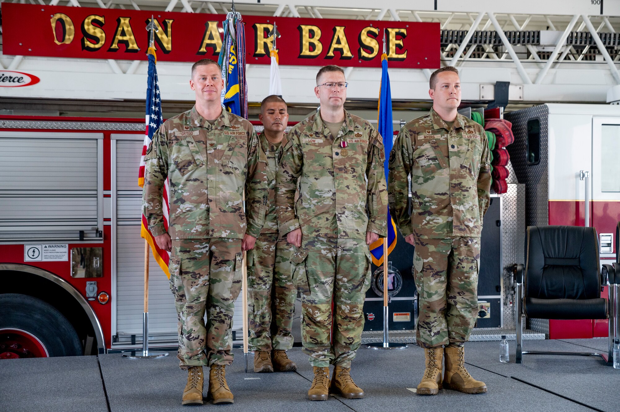 U.S. Air Force Col. Kyle Grygo, left, 51st Mission Support Group commander; Lt. Col. Brian Low, 51st Civil Engineer Squadron (51st CES) outgoing commander; and Lt. Col. Andrew Myers, 51st CES incoming commander, stand at attention during a change of command ceremony at Osan Air Base, Republic of Korea, July 5, 2023.
