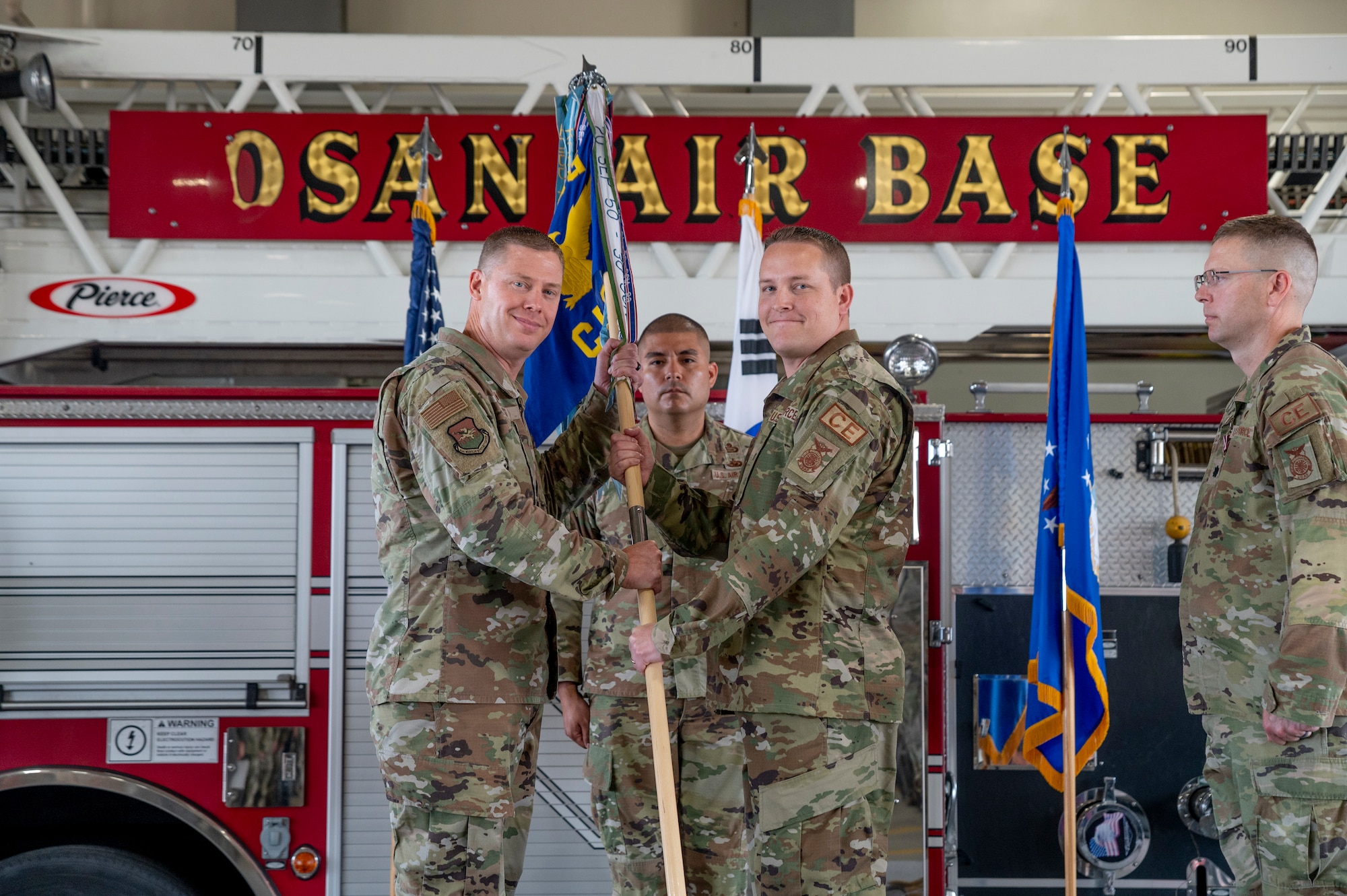 U.S. Air Force Col. Kyle Grygo, left, 51st Mission Support Group commander, presents the guidon to Lt. Col. Andrew Myers, 51st Civil Engineer Squadron (51st CES) incoming commander, as a symbol of taking command at Osan Air Base, Republic of Korea, July 5, 2023.