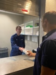 Petty Officer Cameron Guest ceremonially dispenses the first prescription from the re-opened pharmacy to Capt. Dan Rogers, commander of Base New Orleans. The CG is reopening six pharmacies this year to meet the growing demand for CG services by improving how we support our personnel and their families. (U.S. Coast Guard photo by Petty Officer 2nd Class Suzette Arazia.)