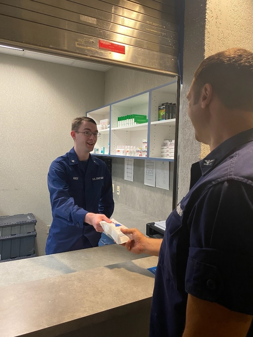 Petty Officer Cameron Guest ceremonially dispenses the first prescription from the re-opened pharmacy to Capt. Dan Rogers, commander of Base New Orleans. The CG is reopening six pharmacies this year to meet the growing demand for CG services by improving how we support our personnel and their families. (U.S. Coast Guard photo by Petty Officer 2nd Class Suzette Arazia.)