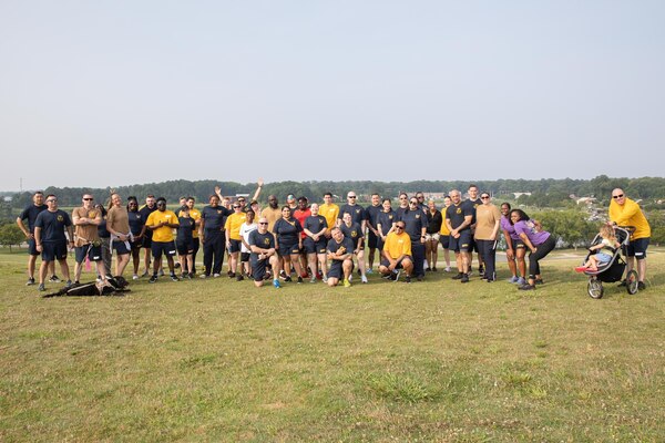 Sailors in physical training uniform pose for a group photo