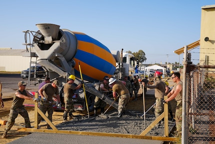 Members from the 152nd Civil Engineer Squadron, Nevada Air National Guard, pour concrete during construction of a pavement approach at Moron Air Base, Spain, June 26, 2023. The 152nd engineers were in Spain for Deployment For Training to increase readiness and expand skills.