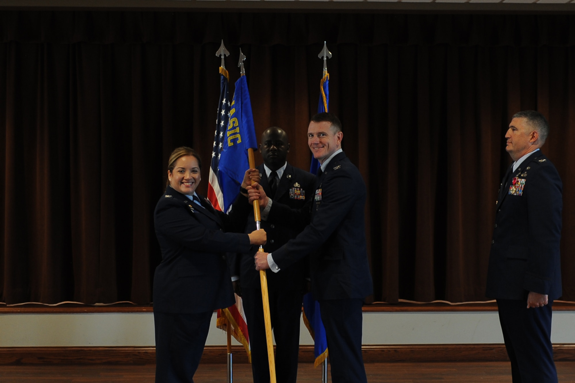 Col. Ariel G. Batungbacal, left, National Air and Space Intelligence Center commander, presents the guidon to Col. Brian McCreary, inbound Global Exploitation Intelligence Group commander, during the group’s change of command ceremony at Wright-Patterson Air Force Base, Ohio, June 30, 2023. Earlier in the ceremony, Batungbacal, gave opening remarks where she both welcomed McCreary and expressed appreciation for outbound commander Col. Kenneth Stremmel, thanking him for his contributions to national security. (U.S. Air Force photo by Senior Airman Kendall Stuckman)