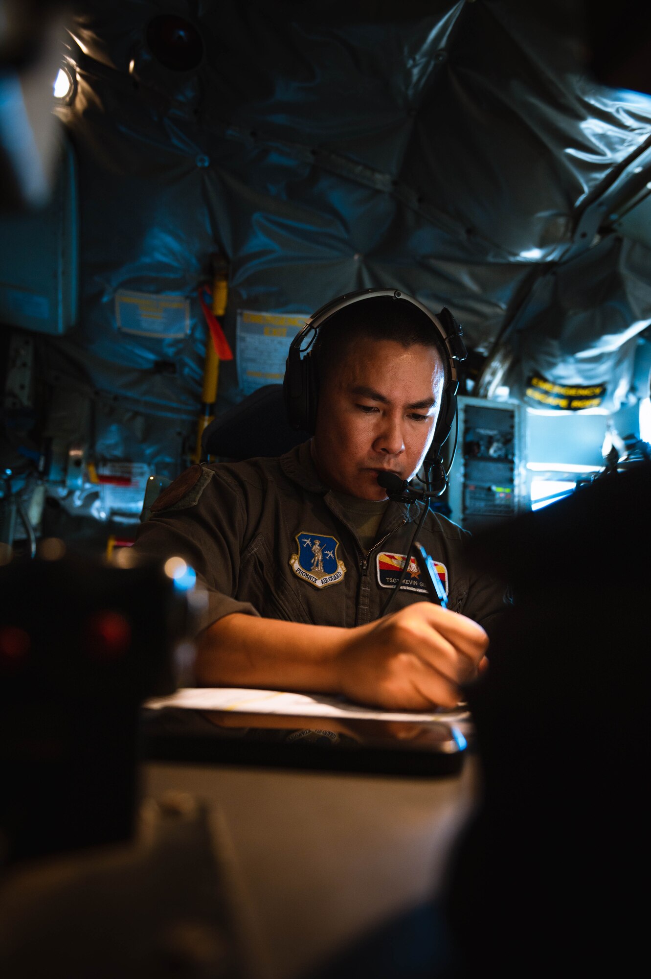 U.S. Air National Guardsman Tech Sgt. Kevin Gimenez, 161st Air Refueling Wing boom operator, prepares flight paperwork.