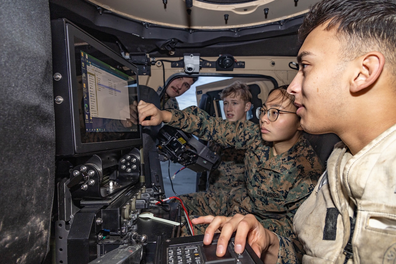 Troops look at a computer screen.