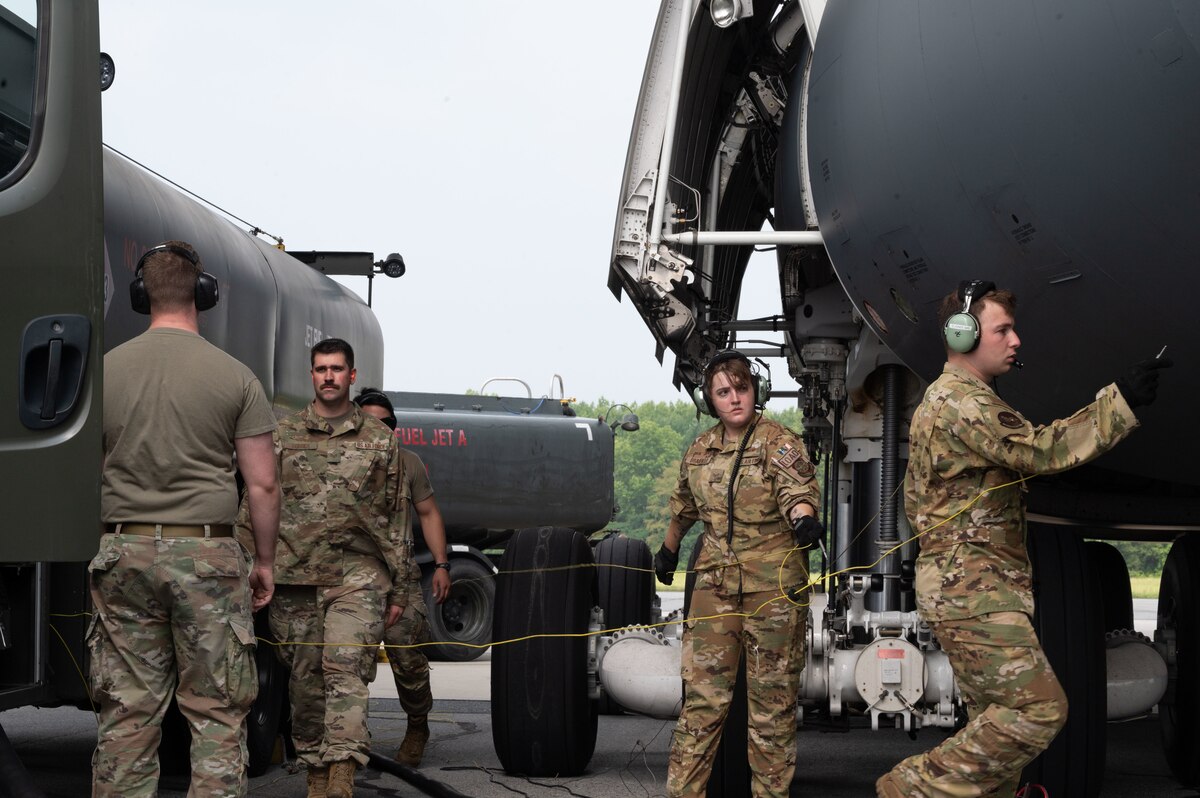 Team Dover members prepare a C-5M Super Galaxy for a wet wing defuel at Dover Air Force Base, Delaware, June 28, 2023. A wet wing defuel removes the fuel from an aircraft and transfers it to a R-11 fuel truck while the engines are still running in order to decrease aircraft ground time. (U.S. Air Force photo by Airman 1st Class Dieondiere Jefferies