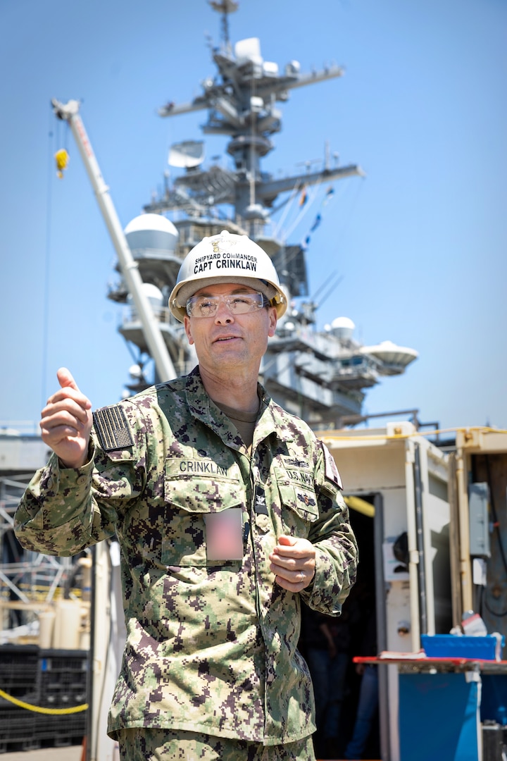 Capt. JD Crinklaw, commander, Puget Sound Naval Shipyard & Intermediate Maintenance Facility, stands near USS Abraham Lincoln (CVN 72) June 28, 2023, while speaking to members of the San Diego Detachment site team, during his first visit there since becoming commander at PSNS & IMF May 25, 2023. Crinklaw also oversees operations at PSNS & IMF Everett Detachment and at the detachment in Yokosuka, Japan. (U.S. Navy photo by Wendy Hallmark)