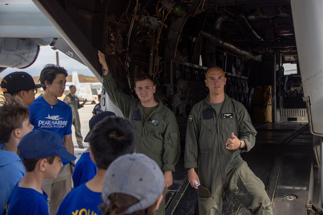 U.S. Marines with Marine Medium Tiltrotor Squadron 268 (VMM-268), Marine Aircraft Group 24, 1st Marine Aircraft Wing, converse with Pearl Harbor Aviation Museum "Flight School" summer camp students, Marine Corps Air Station Kaneohe Bay, Marine Corps Base Hawaii, 27 June, 2023. VMM-268 partnered with the summer camp to introduce middle school students to the aviation career field and enhance community relations. (U.S. Marine Corps photo by Cpl. Logan Beeney)