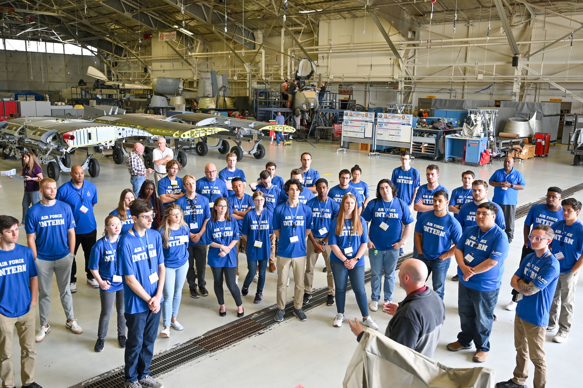 Students listen to a briefer in the A-10 hangar