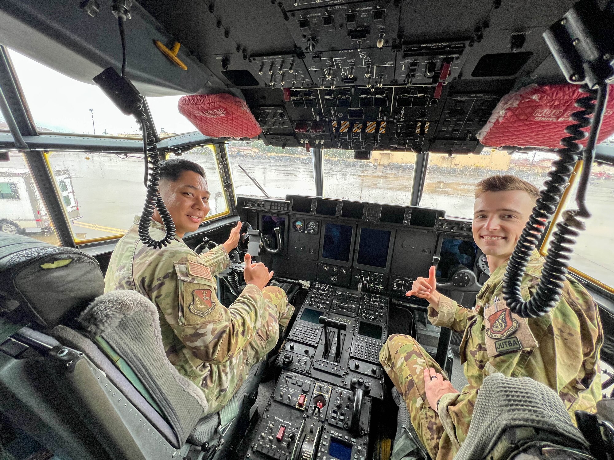 Two service members smile in the cockpit of a transient MC-130J Commando II.