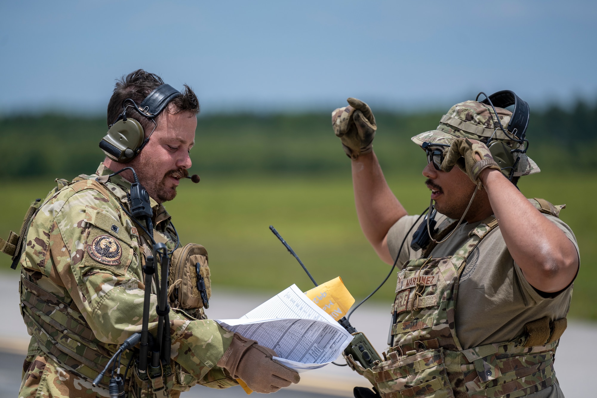 U.S. Air Force Staff Sgt. Taylor Beams, left, and, Staff Sgt. Andres Martinez, right, both are assigned to the 621st Mobility Support Operations Squadron as enlisted air/ground liaison element (EAGLE) team members, coordinate how to onload cargo to a C-17 Globemaster aircraft during Exercise SWAMP AVENGER at North Field, South Carolina, May 25, 2023.