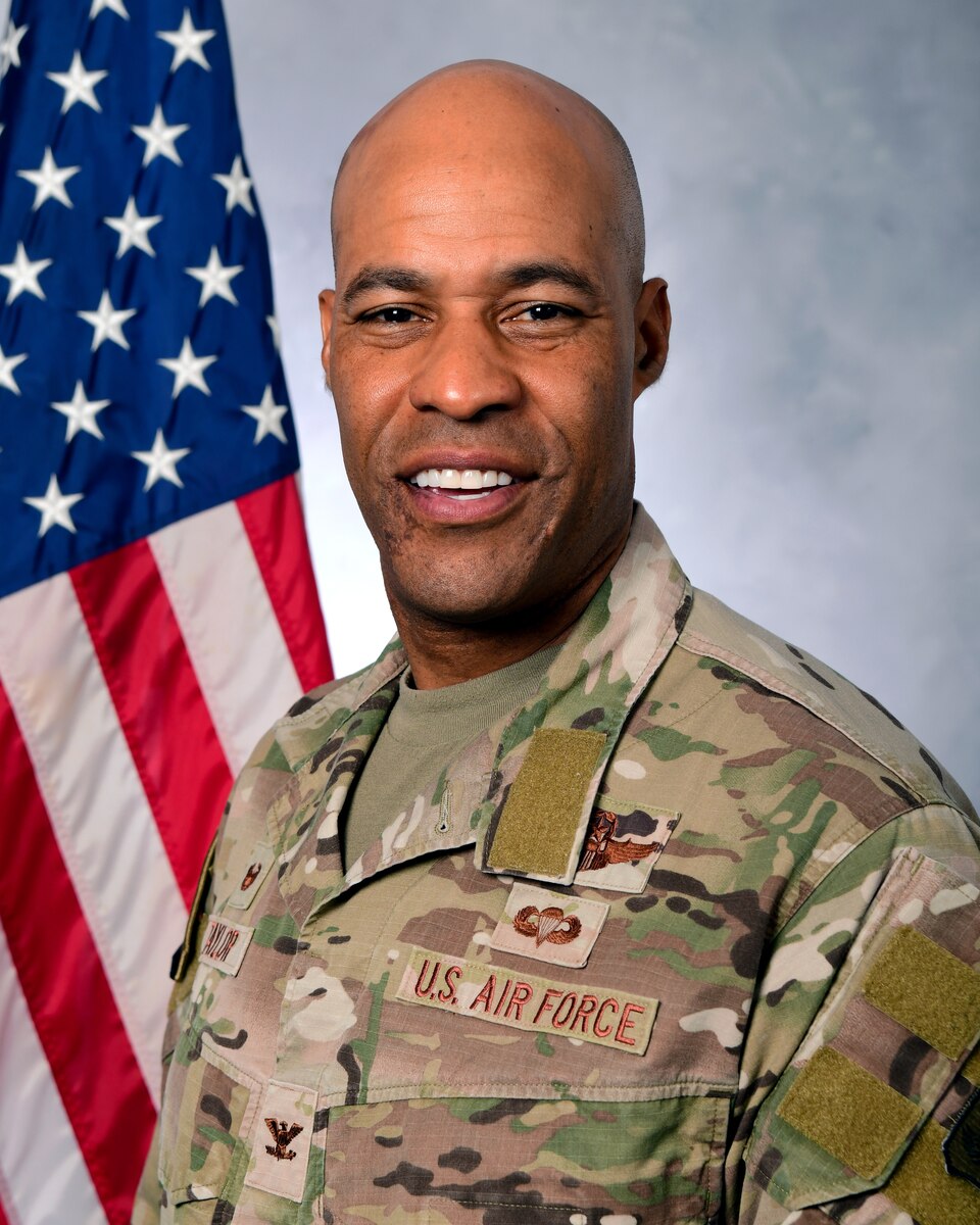 A photo of a man in from of the U.S. Flag.