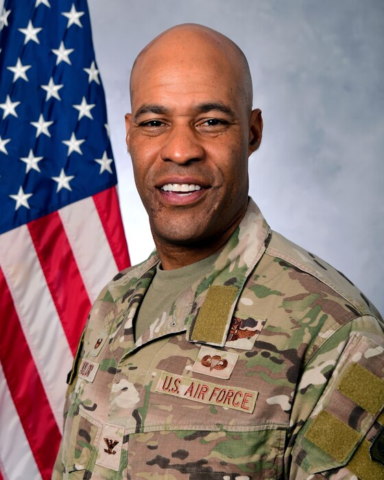 A photo of a man in from of the U.S. Flag.