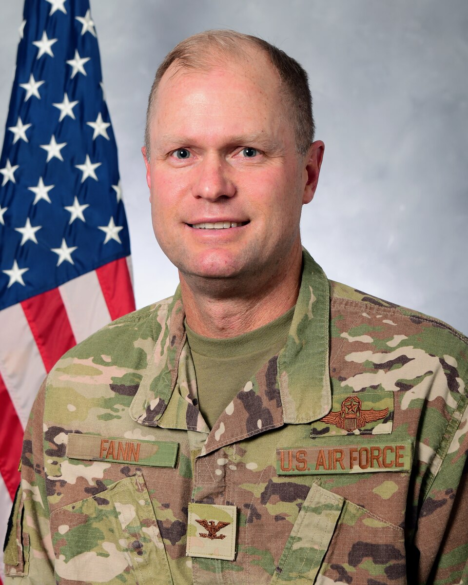 A photo of a man in from of the U.S. Flag.