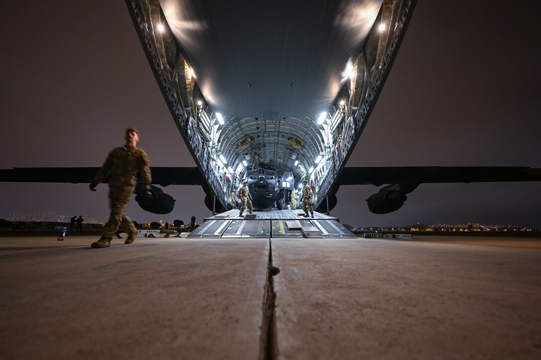 A helicopter sits in a large aircraft.