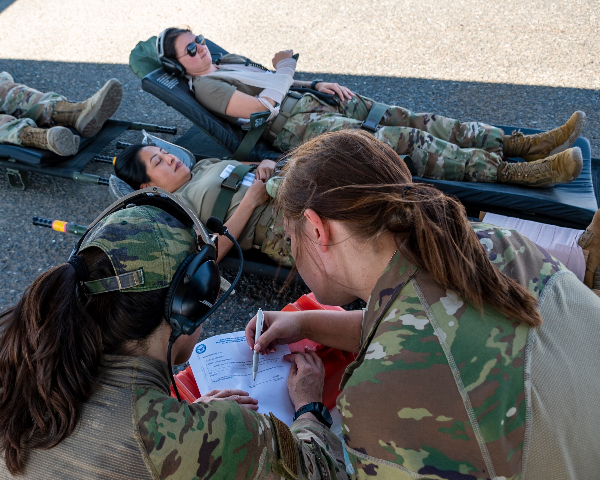 U.S. Air Force Tech. Sgt. Kelly Mosley, left, and Staff Sgt. Ariel Kuhl, right, review baggage form and anti-hijacking form to clear patients for on-load of the aircraft, during a combined 405 Expeditionary Aeromedical Evacuation Squadron (EAES), and 379 EAES Critical Care Air Transport Team (CCATT) training at Ali Al Salem Air Base, Kuwait, June 29, 2023.